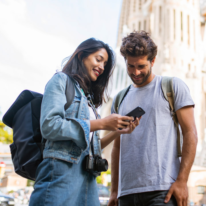 Zwei Touristen mit Smarthphone in Barcelona