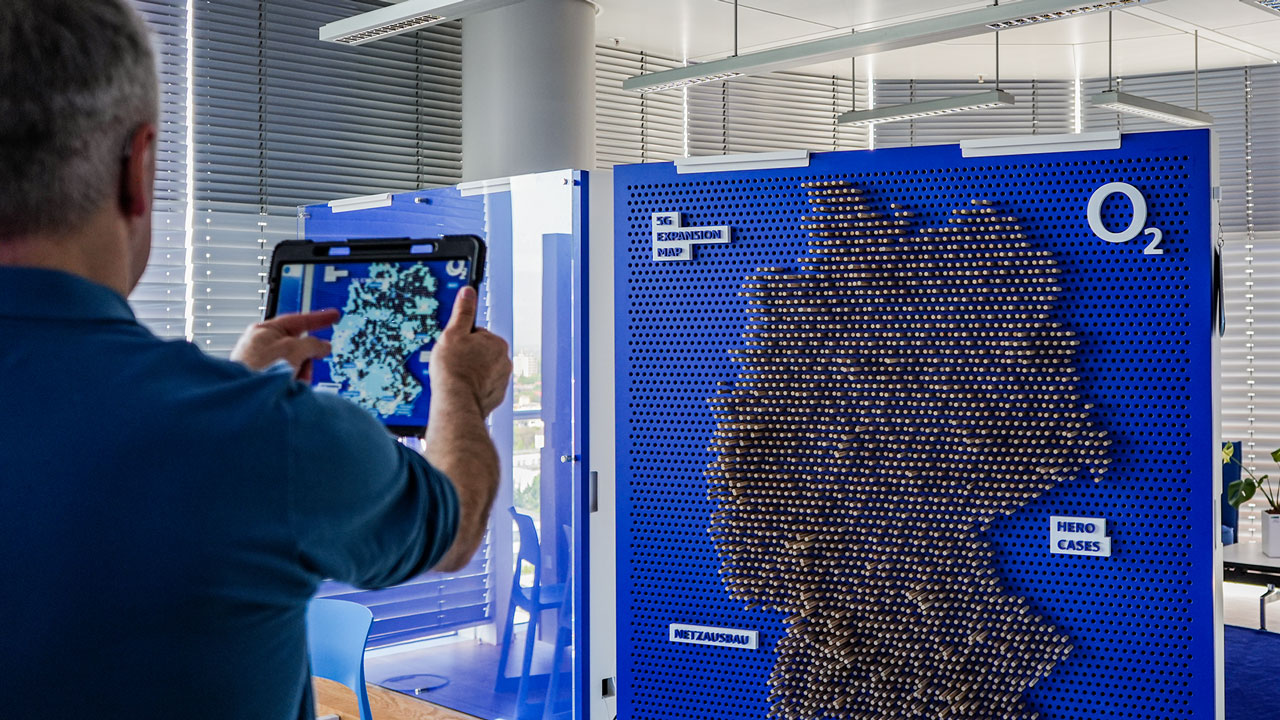 Mann mit Tablet in einem 5G-Workshop. Link zur Innovation Experience Area Seite.