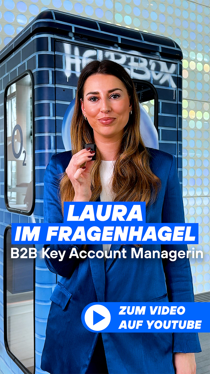 Laura steht mit Mikrofon in der Münchner Lobby vor der Telefonzelle