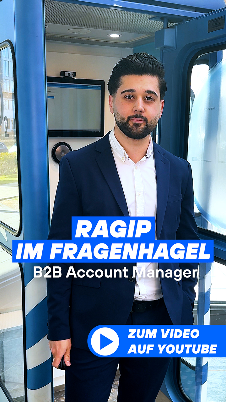 Ragip steht mit Mikrofon in der Düsseldorfer Lobby vor der Telefonzelle