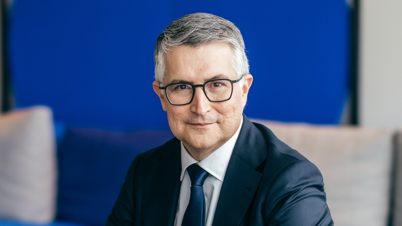 Klick aufs Bild startet JPG-Download: Santiago Argelich Hesse sitzend und lächelnd